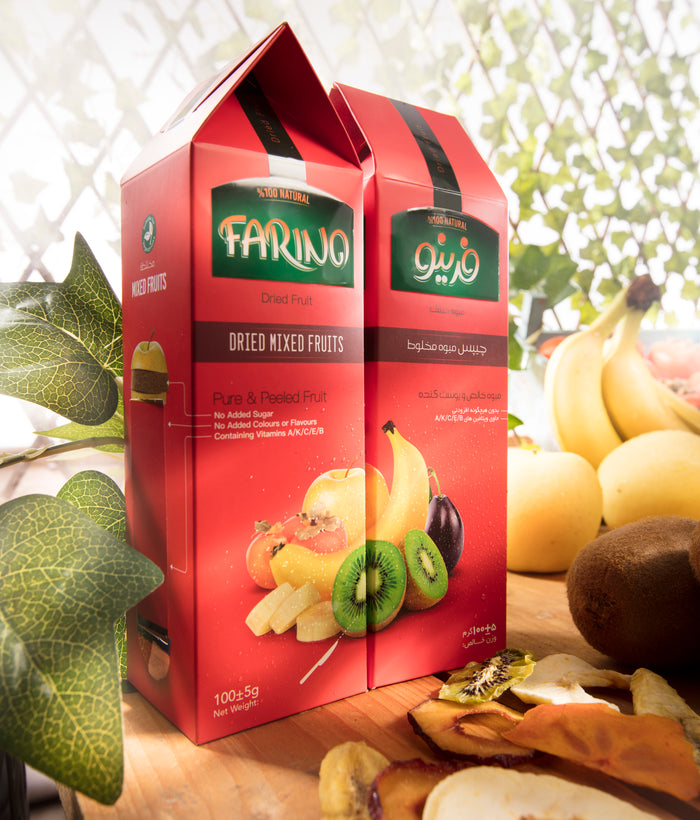 Two red boxes of Farina dried mixed fruits on a wooden surface with fruits in the background.