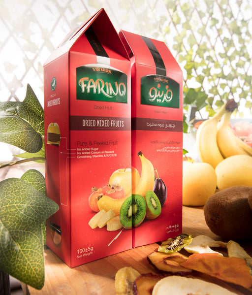 Two red boxes of Farina dried mixed fruits on a wooden surface with fruits in the background.