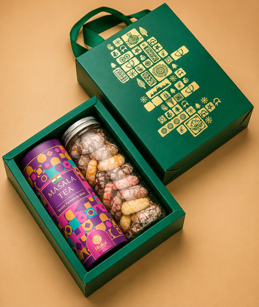 Gift set with a colorful tea canister and a jar of assorted candies in a green box on a beige background.