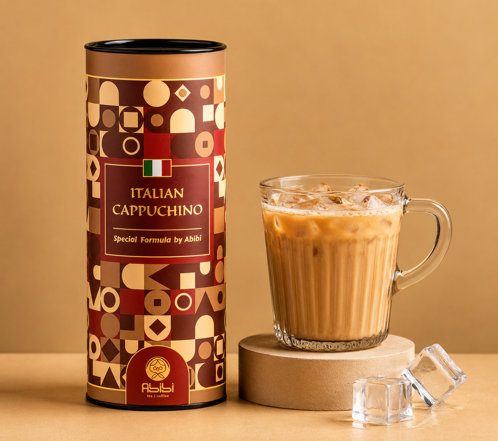Cylindrical container labeled 'Italian Cappuccino' next to a glass of cappuccino on a beige background